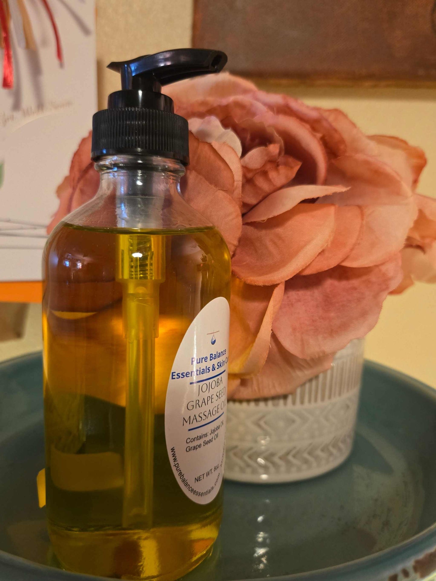 Jojoba and grapeseed massage oil for pain relief, 8oz bottle on display.