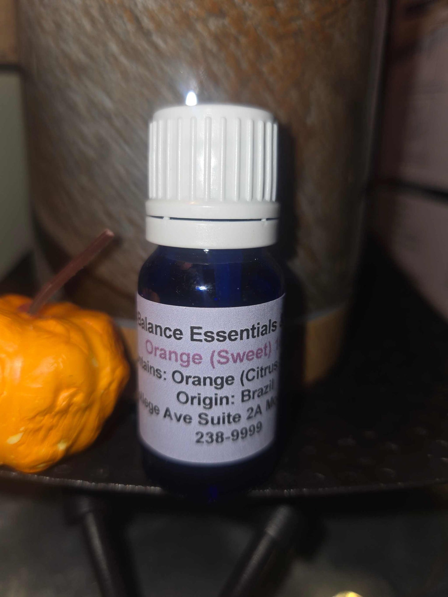 essential oil bottle next to small decorative pumpkin.