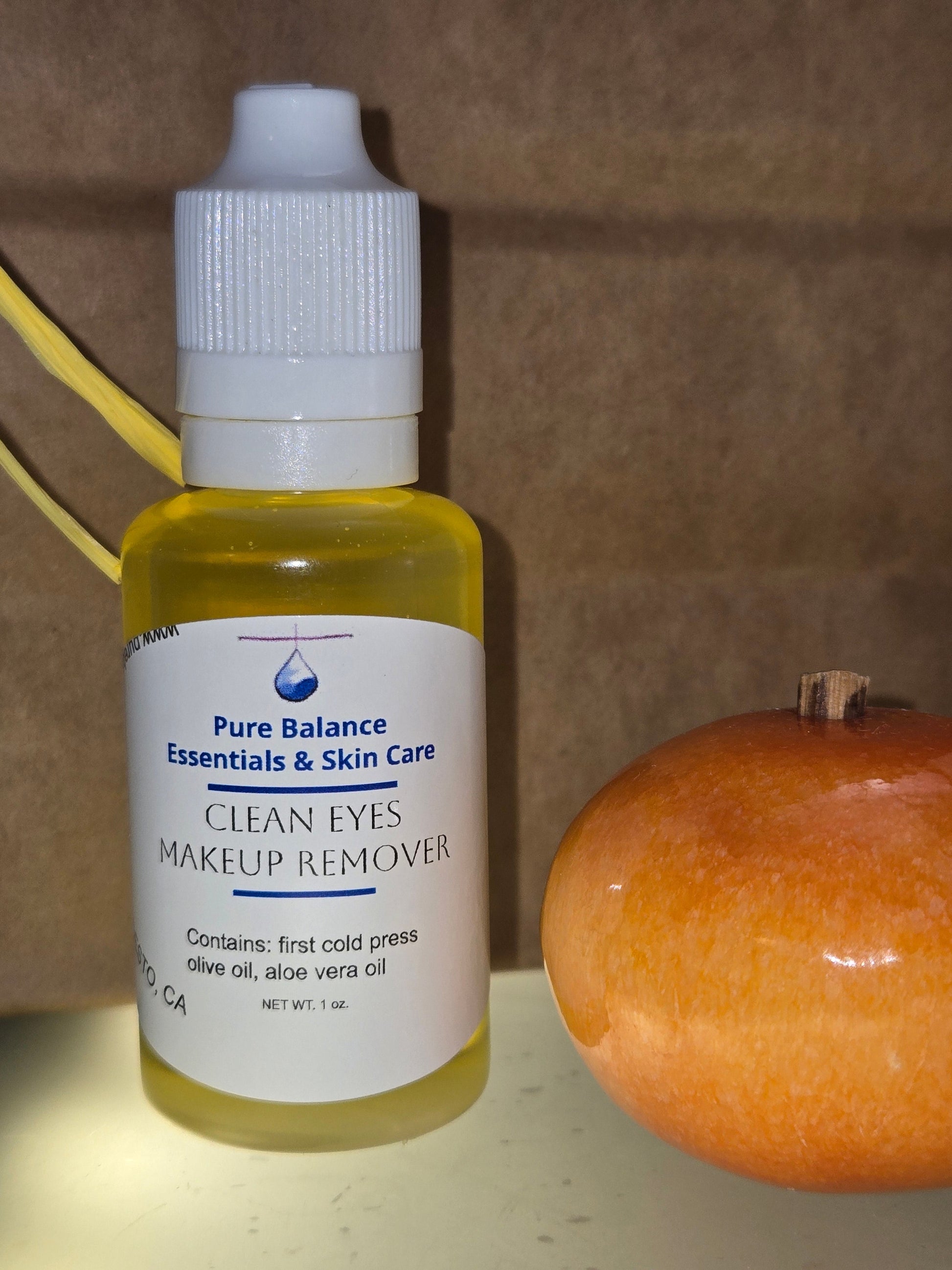 CLEAN EYES MAKEUP REMOVER small bottle with olive oil and aloe vera oil next to a brown fruit