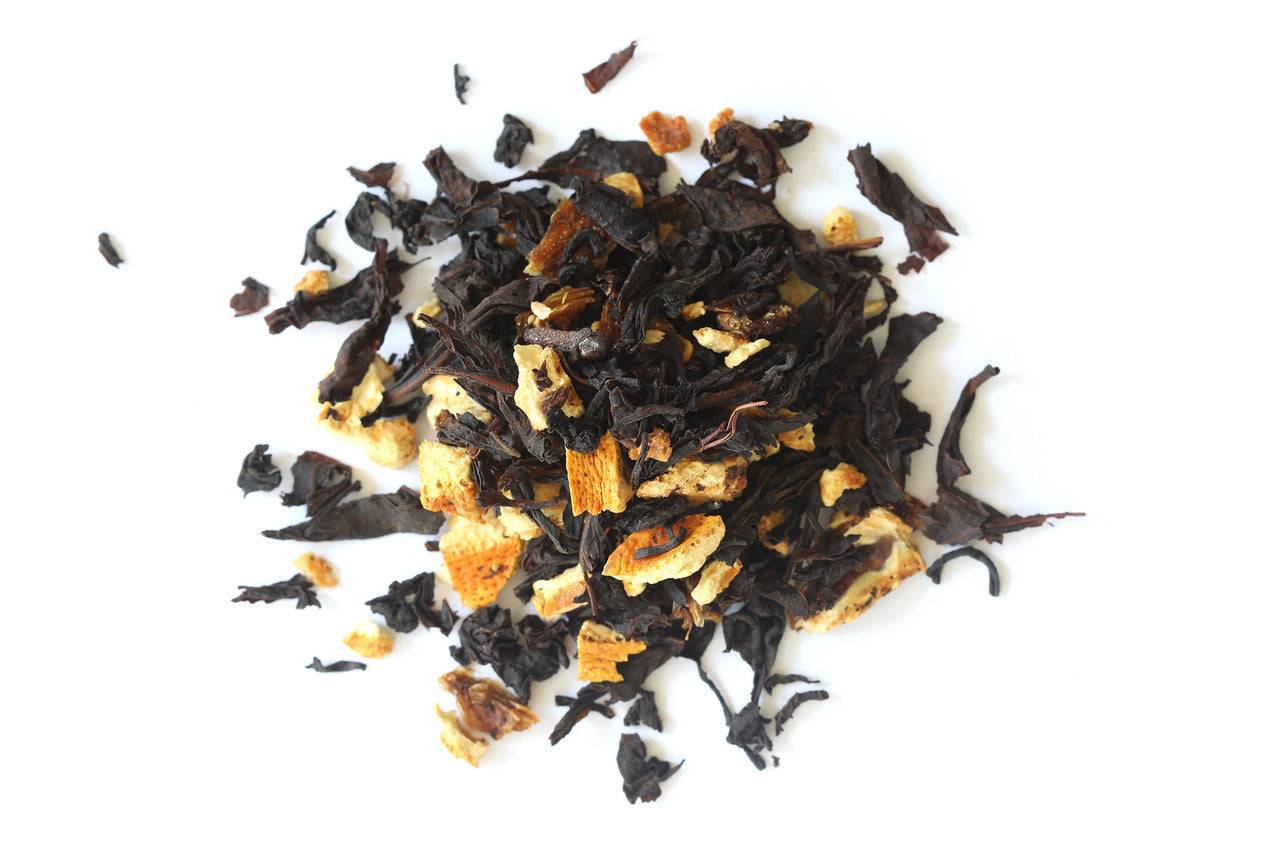 Cup of Orange Spice Tea with orange peel and cinnamon sticks on a wooden table