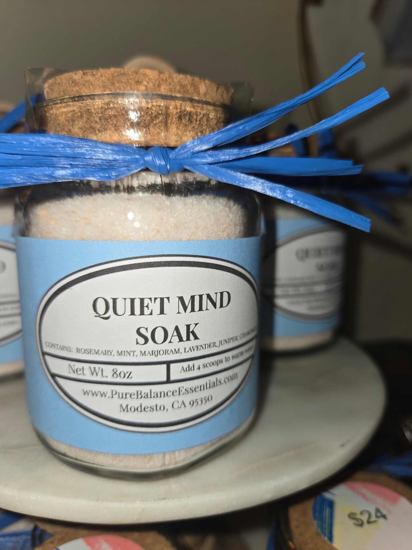 Glass jar of Quiet Mind Soak pink Himalayan salt with essential oils and stainless steel spoon for relaxation bath