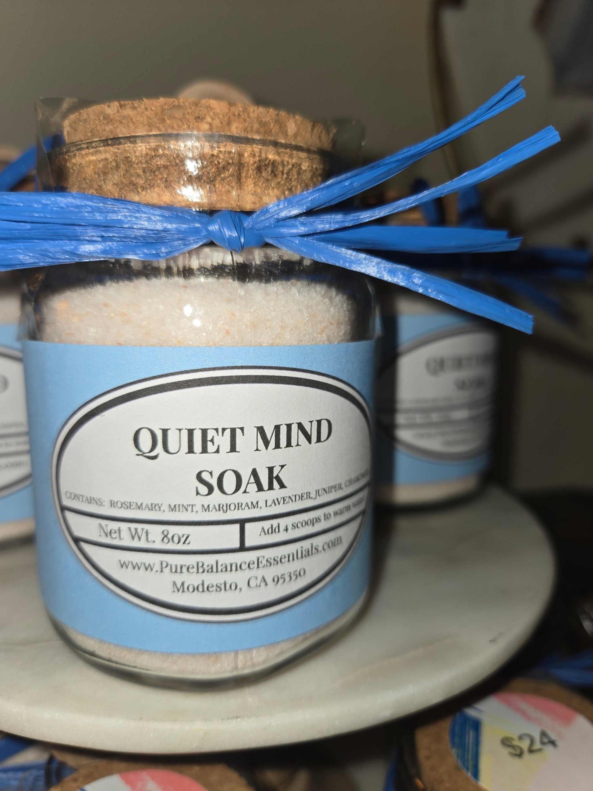 Glass jar of Quiet Mind Soak pink Himalayan salt with essential oils and stainless steel spoon for relaxation bath