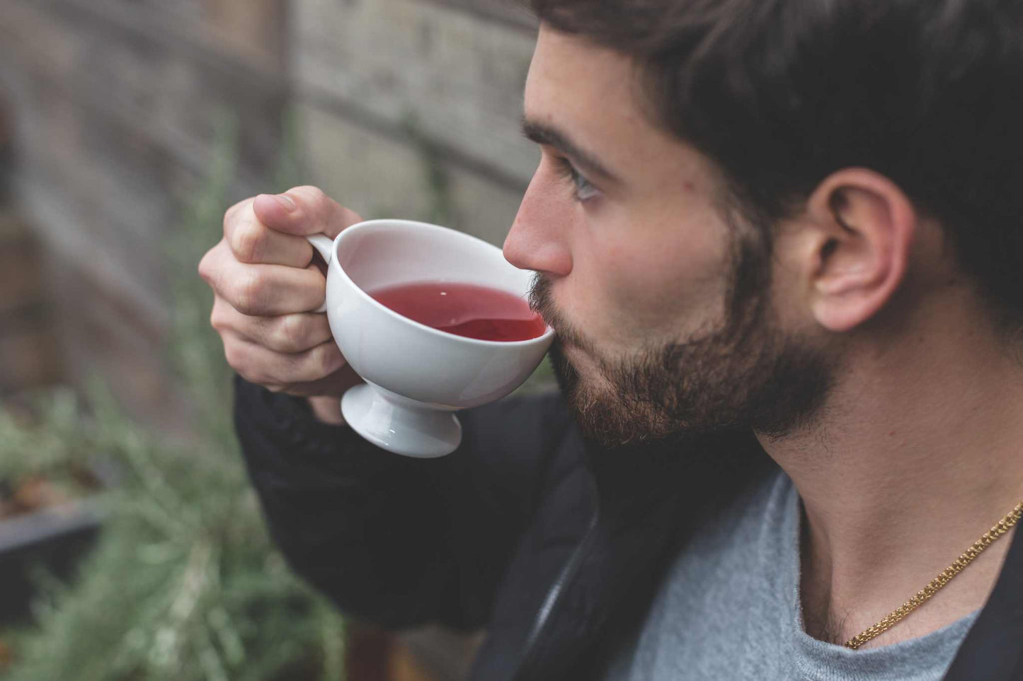 Cup of organic vanilla rooibos tea with vanilla pods and elder flowers on a wooden table