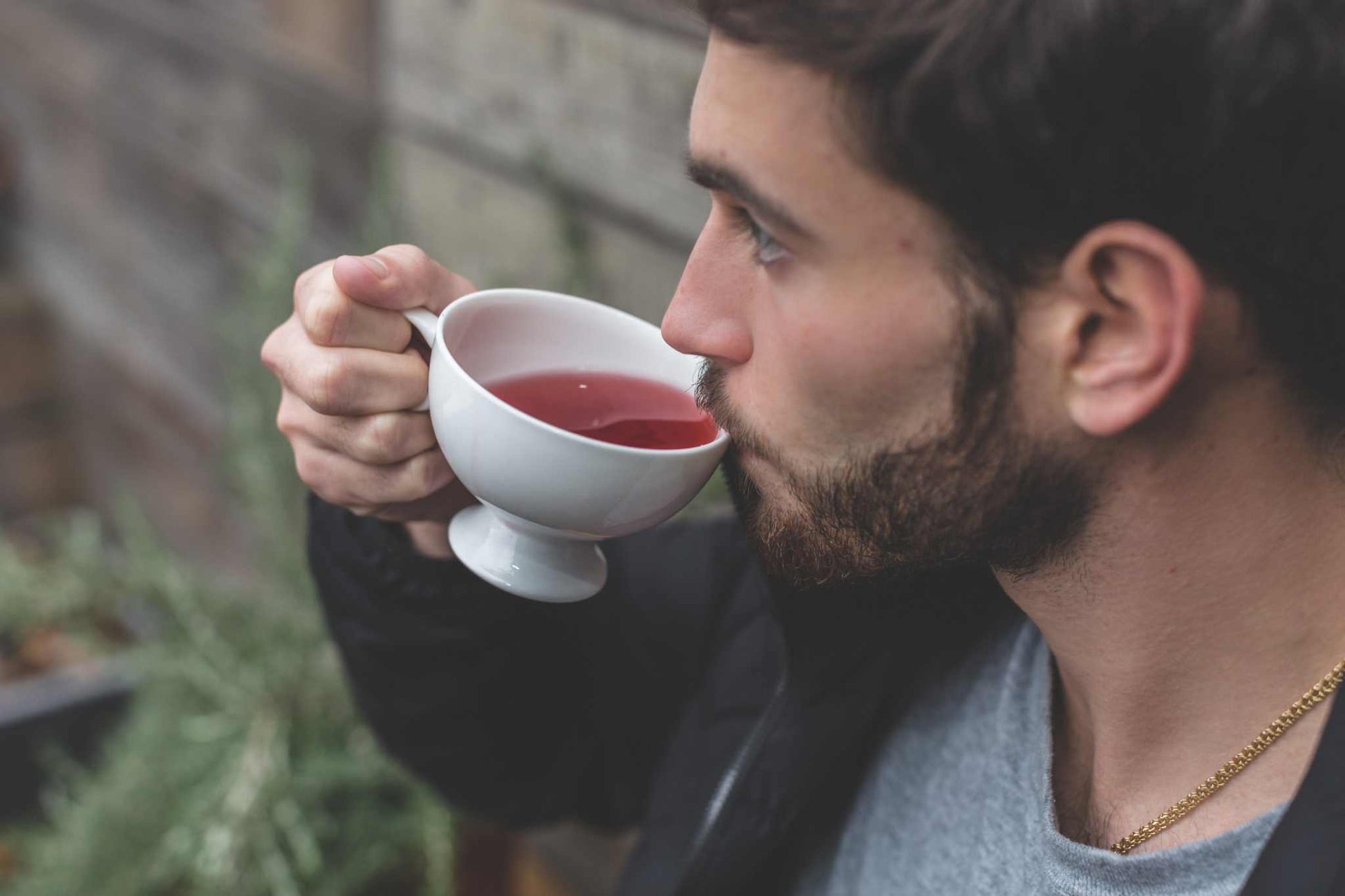 Cup of organic vanilla rooibos tea with vanilla pods and elder flowers on a wooden table